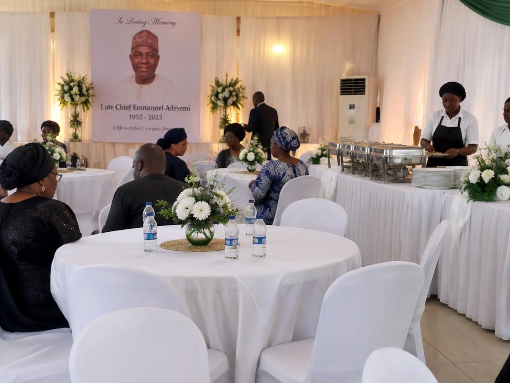 Memorial reception hall with white draped tables and floral arrangements